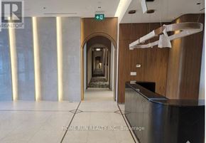 Ottawa condo for rent - A hallway with a reception desk and a green exit sign.