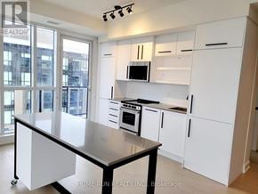 Ottawa condo for rent - A kitchen with white cabinets and a black island.