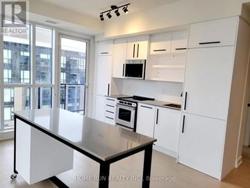 Ottawa condo for rent - A kitchen with white cabinets and a black island.