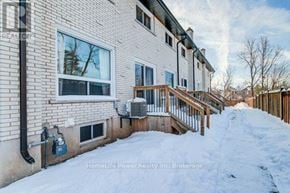 Cambridge townhouse for rent - A snow-covered walkway leads to a two-story building with a balcony.