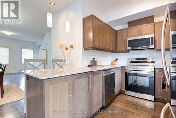 Kitchener townhouse for rent - A kitchen with wooden cabinets and stainless steel appliances.