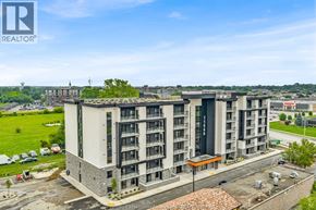 Windsor condo for rent - A modern apartment building with a parking lot in front.