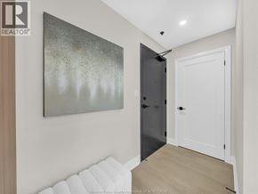 Windsor condo for rent - A hallway with a painting on the wall and a black door.