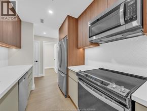 Windsor condo for rent - A kitchen with a refrigerator, oven, and microwave.