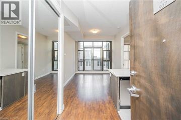 Hamilton condo for rent - A modern kitchen with a wooden floor and white walls.