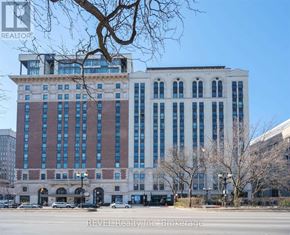 Hamilton (Beasley) condo for rent - A large building with a white facade and blue windows is the main focus of the image.