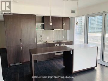 Toronto (Waterfront Communities) condo for rent - A modern kitchen with dark wood cabinets and a white island.
