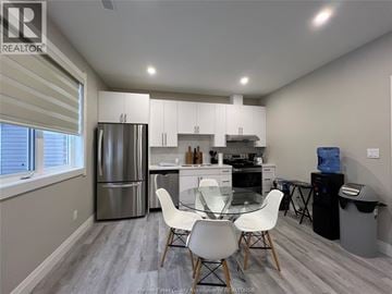 Windsor house for rent - A kitchen with a refrigerator, dining table, and chairs.