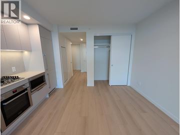 Coquitlam apartment for rent - A kitchen with a stove top oven and a refrigerator.