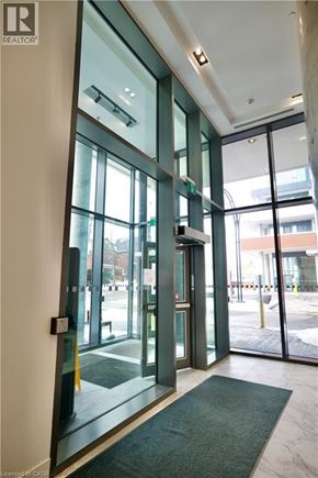 Kitchener condo for rent - A glass door with a handle and a green mat in front of it.