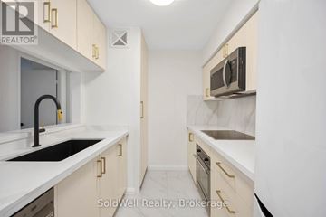 Toronto (Bay Street Corridor) condo for rent - A kitchen with white cabinets and a black counter top.