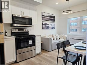 St. Catharines apartment for rent - A modern kitchen with a black oven and microwave above a white cabinet.