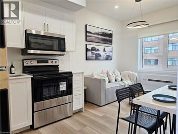 St. Catharines apartment for rent - A modern kitchen with a black oven and microwave above a white cabinet.
