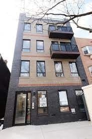 Brooklyn apartment for rent - A tall building with balconies on the upper floors.