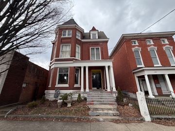 Louisville apartment for rent - A red brick house with a black fence in front.