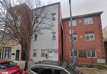 Chicago apartment for rent - A red car is parked in front of a grey and red building.