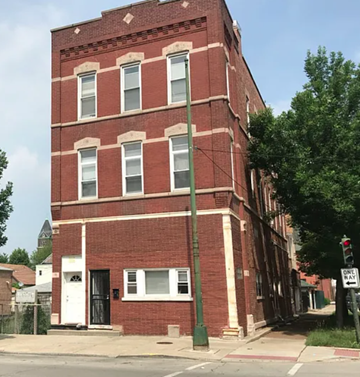 Chicago apartment for rent - A red brick building with a white door and windows.