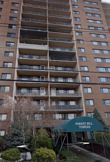Newark apartment for rent - A tall building with balconies and a sign that says Forest Hill Towers.