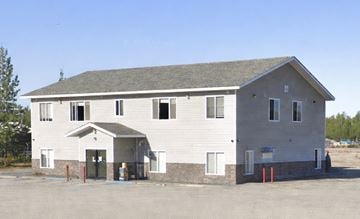 Wasilla apartment for rent - A grey building with a green door and windows.