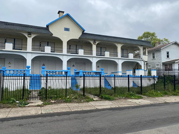 Columbus apartment for rent - A white building with blue trim and a black fence.