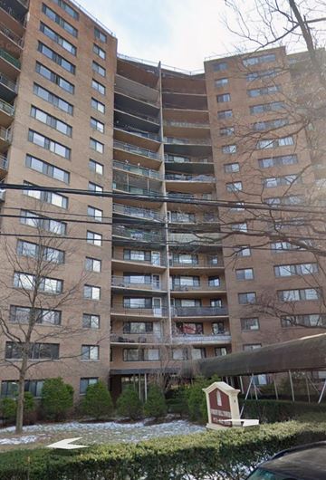 Newark apartment for rent - A small red and white house is in front of a large apartment building.