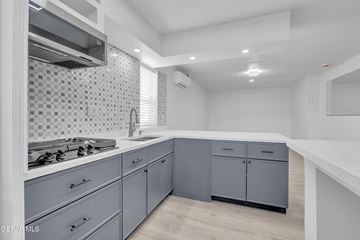 El Paso apartment for rent - A modern kitchen with a stove top oven and a tiled backsplash.