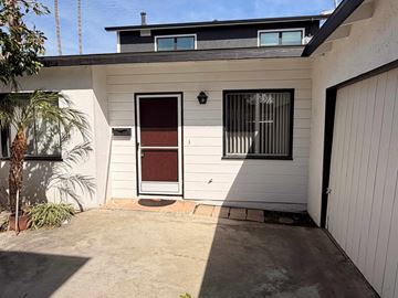 San Clemente apartment for rent - A white house with a brown door and a window with bars.