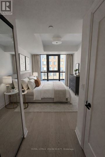 Toronto (Englemount-Lawrence) condo for rent - A bedroom with a large bed and a view of a city skyline.