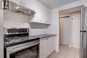 London East (East F) condo for rent - A kitchen with a stove top oven and a refrigerator.