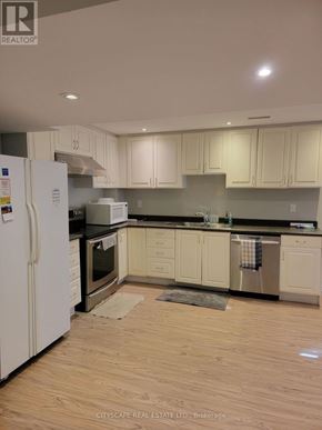 Brampton (Fletcher's Creek South) apartment for rent - A kitchen with white cabinets and a white refrigerator.