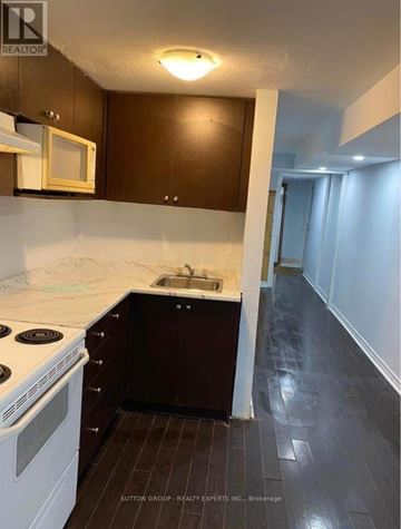 Mississauga (Clarkson) apartment for rent - A kitchen with dark wood cabinets and white appliances.