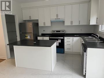 Essa (Angus) townhouse for rent - A kitchen with white cabinets and black countertops.