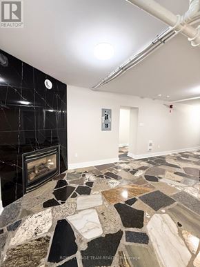 Ottawa apartment for rent - A stone fireplace in a room with a black tile wall.