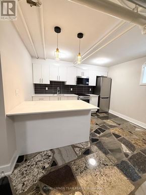 Ottawa apartment for rent - A kitchen with a white island and a stone floor.