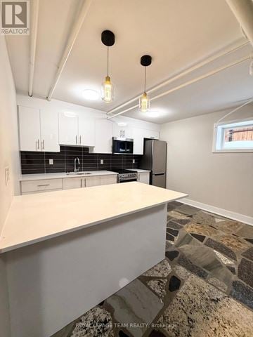 Ottawa apartment for rent - A kitchen with white cabinets and a stone floor.