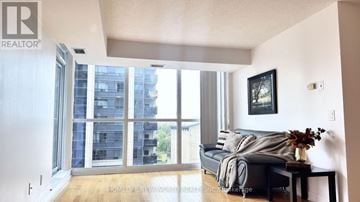 Toronto (Willowdale West) condo for rent - A living room with a grey couch and a large window.