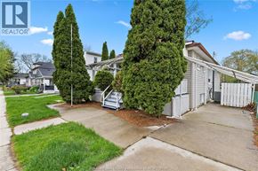 Windsor apartment for rent - A realtor photo of a residential area with a house and trees.