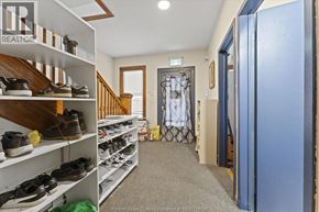 Windsor apartment for rent - A hallway with a shoe rack on the left and a blue door on the right.