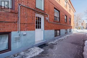 Toronto (East End-Danforth) duplex for rent - A red brick building with a white door and windows.