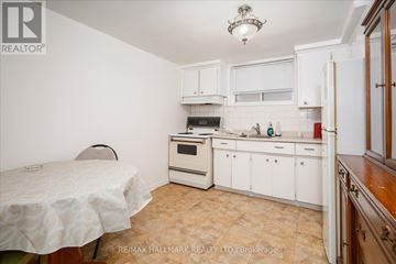 Toronto (East End-Danforth) duplex for rent - A kitchen with white cabinets and a table with a white tablecloth.