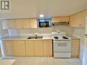 Toronto (Trinity-Bellwoods) apartment for rent - A kitchen with a white stove and cabinets.
