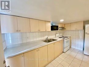 Toronto (Trinity-Bellwoods) apartment for rent - A kitchen with white cabinets and appliances.