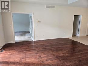 Windsor townhouse for rent - A room with wooden floors and white walls, with a doorway leading to another room.