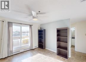 Grande Prairie apartment for rent - A room with a sliding glass door, a ceiling fan, and a built-in shelf unit.