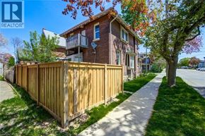 Brantford apartment for rent - A brown wooden fence in front of a brick house.
