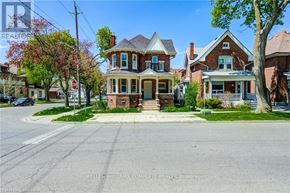Brantford apartment for rent - A street view of a residential area with houses and trees.