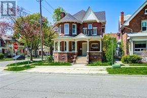 Brantford apartment for rent - A brick house with a porch and a sign that says "STOP" in front of it.