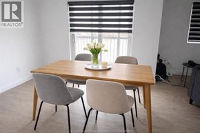 Lasalle apartment for rent - A dining table with four chairs and a vase of flowers on top.