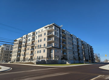 Riverview apartment for rent - A large apartment building with a curved corner and a street in front.