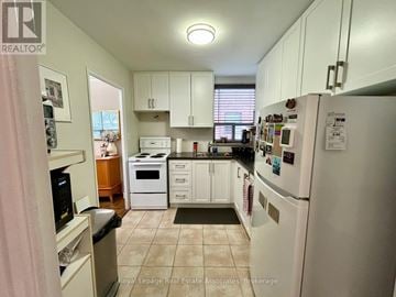 Toronto (Englemount-Lawrence) multi-family for rent - A kitchen with white appliances and cabinets.